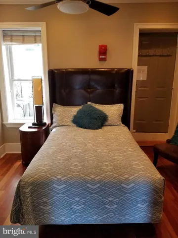 a bedroom with a bed and wooden floor