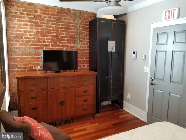 a living room with a dresser and a flat screen tv