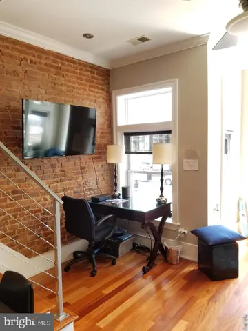 a view of a livingroom with workspace and a window