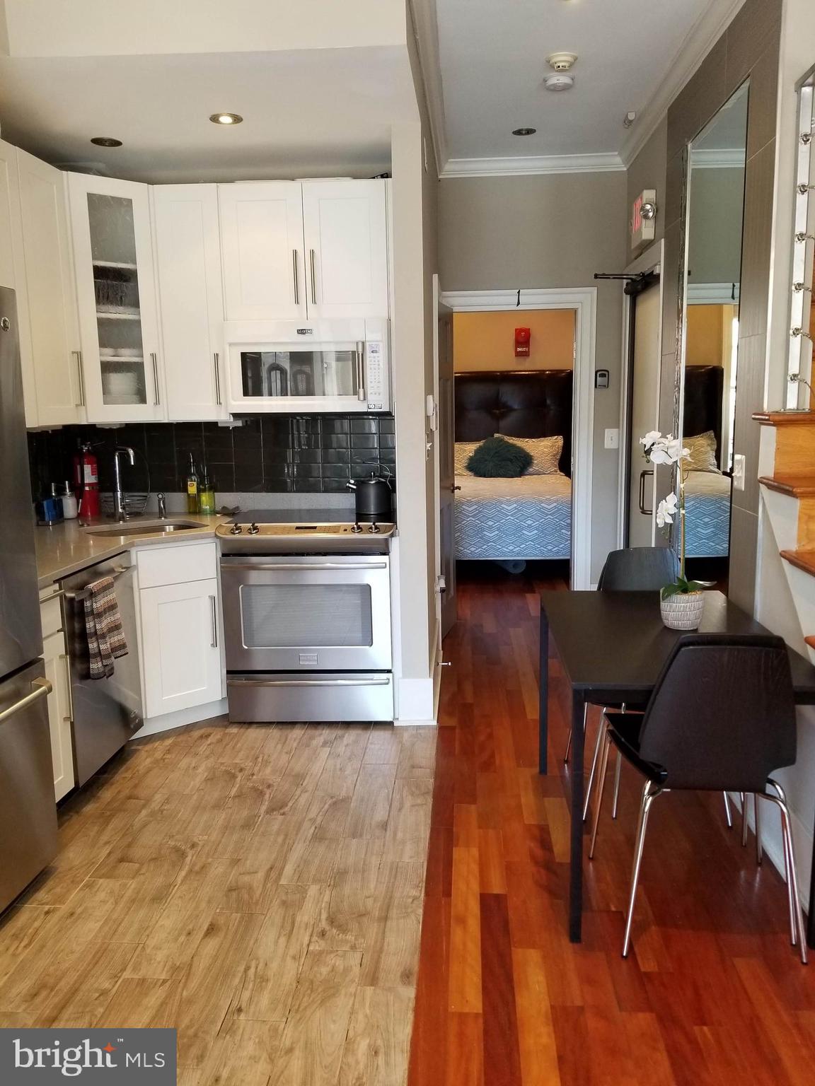 1203 U Street Northwest Washington, DC 20009 - Photo 10 of 40 a kitchen with stainless steel appliances granite countertop a stove a sink and a microwave
