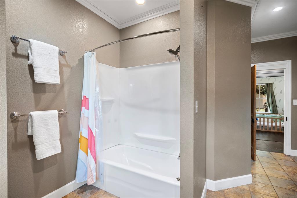202 North Kickapoo Street Lipan, TX 76462 - Photo 13 of 38 Tub and shower combination with white surround, recessed lighting, and tile flooring
