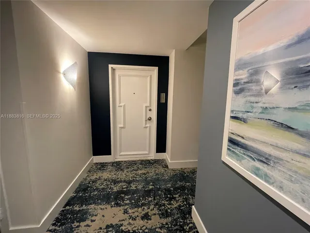 a view of an empty room with wooden floor and windows