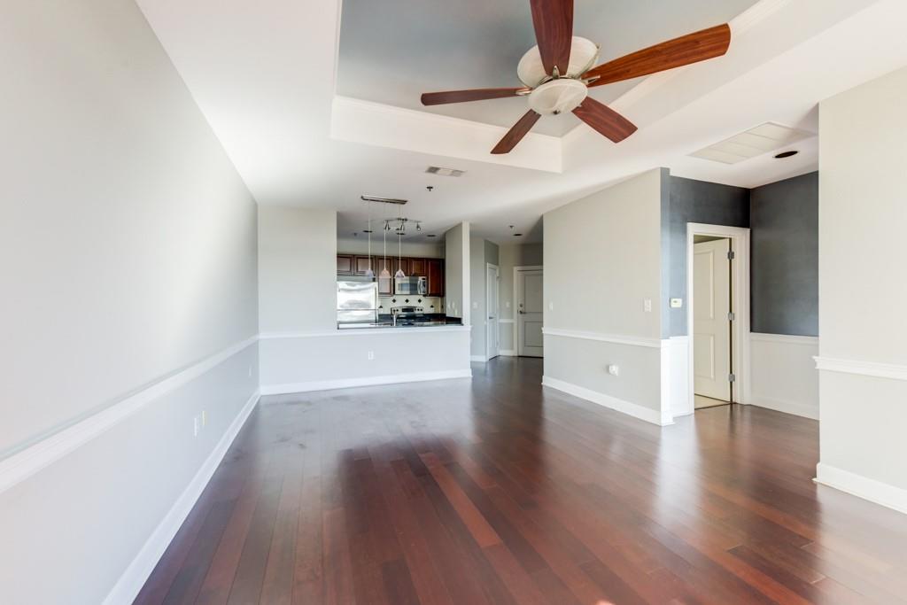 325 East Paces Ferry Road Northeast, Unit 1706 Atlanta, GA 30305 - Photo 4 of 22 a view of a big room with wooden floor a ceiling fan and windows
