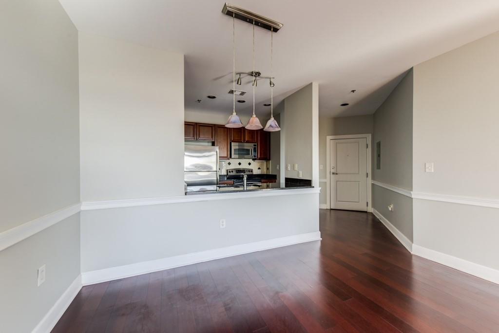 325 East Paces Ferry Road Northeast, Unit 1706 Atlanta, GA 30305 - Photo 8 of 22 a view of a kitchen with wooden floor and a ceiling fan