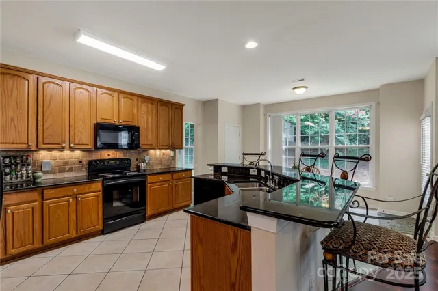 a kitchen with sink cabinets and stove top oven
