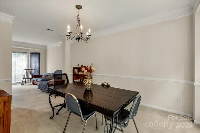a view of a dining room with furniture and chandelier