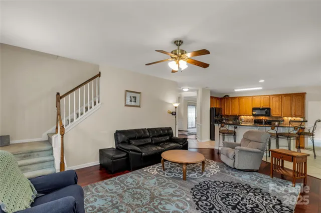 a living room with furniture ceiling fan and a rug