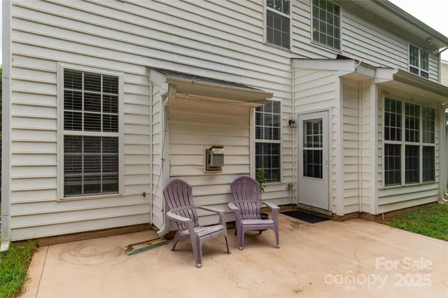 a view of a chair and table in the back yard of the house
