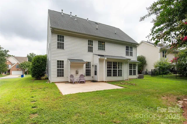 a front view of house with a garden and trees
