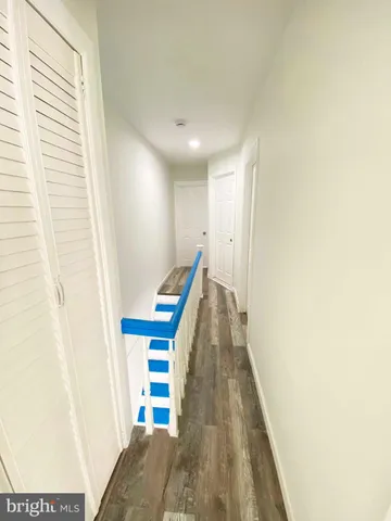 a view of an empty room with wooden floor and stairs