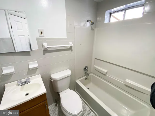 a white toilet sitting next to a bathroom sink and a mirror