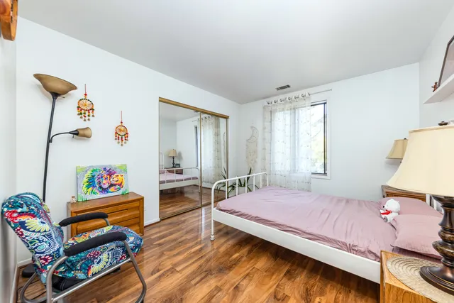 a bedroom with a bed and a wooden floor