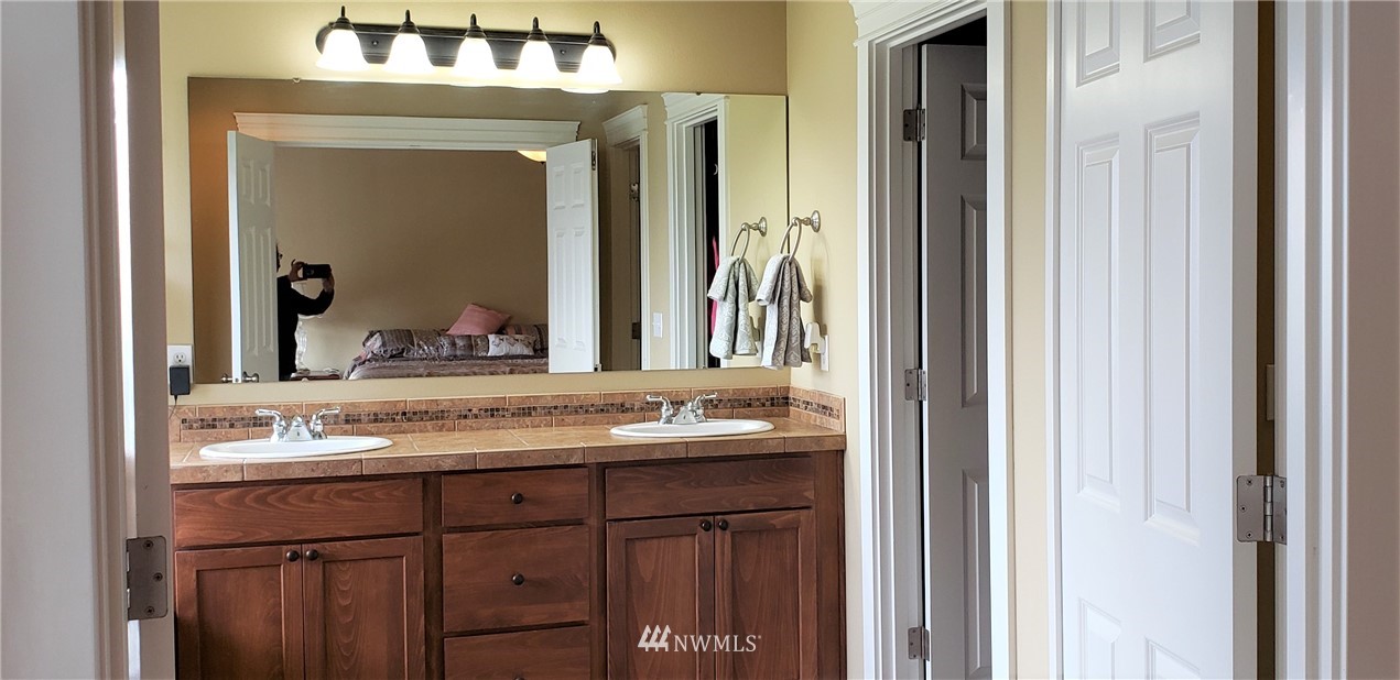 17834 Kenworth Lane Southwest Rochester, WA 98579 - Photo 17 of 29 a bathroom with a granite countertop sink and a mirror