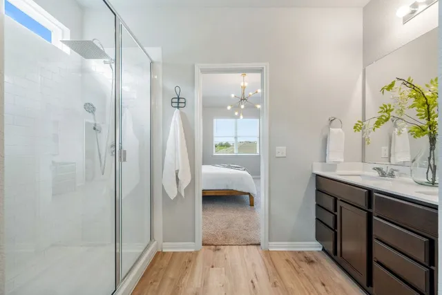 a en suite bathroom with a granite countertop sink and a mirror