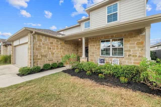 front view of a brick house with potted plants
