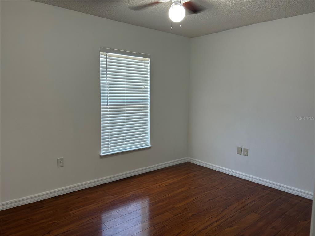 673 Eldron Avenue Deltona, FL 32738 - Photo 17 of 21 an empty room with wooden floor and windows