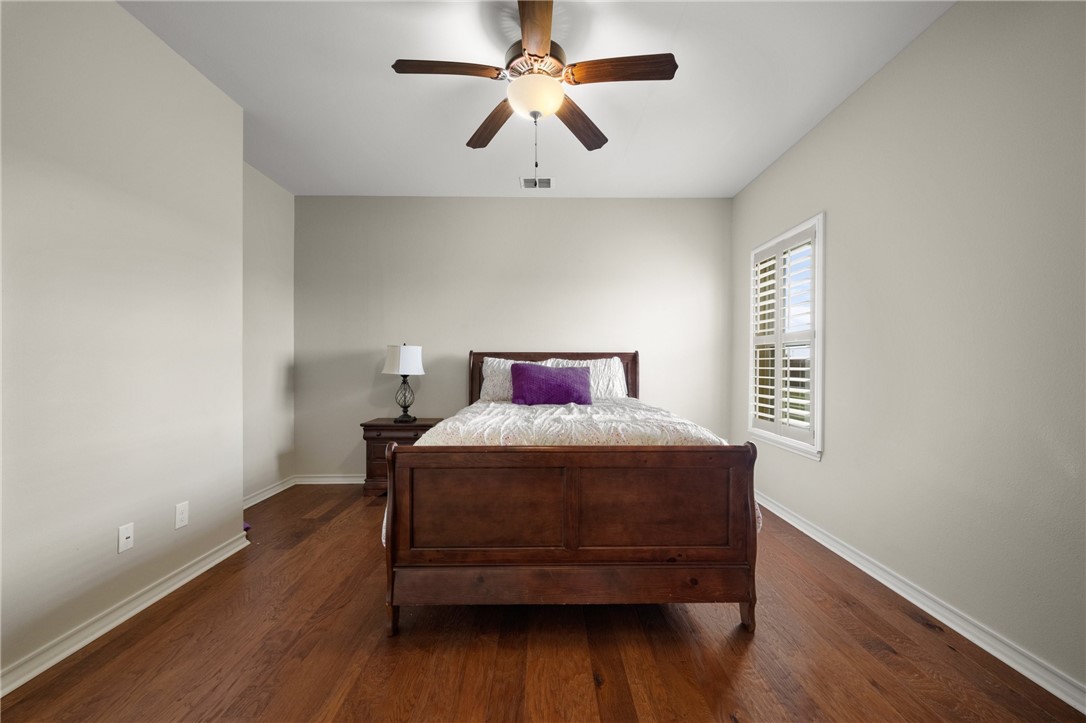 5310 Capernaum Court Corpus Christi, TX 78413 - Photo 21 of 40 a bedroom with a bed and wooden floor