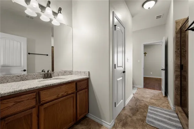 a bathroom with a granite countertop sink a light fixture and a mirror