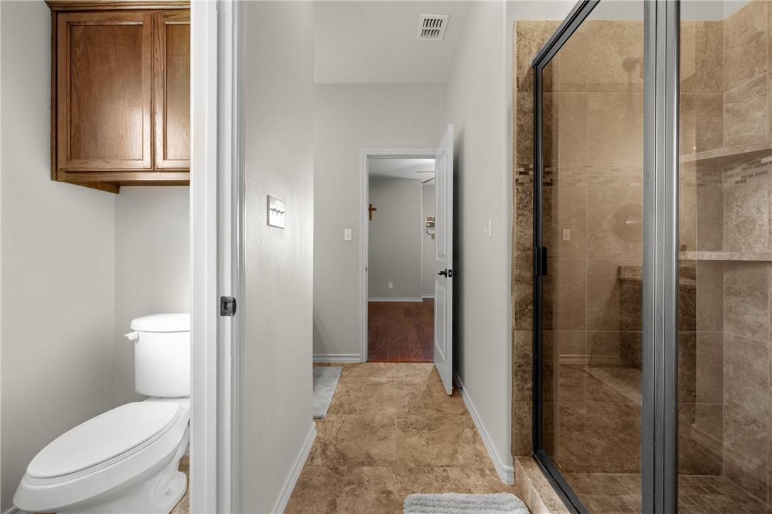 5310 Capernaum Court Corpus Christi, TX 78413 - Photo 24 of 40 a bathroom with a granite countertop toilet a sink and a mirror