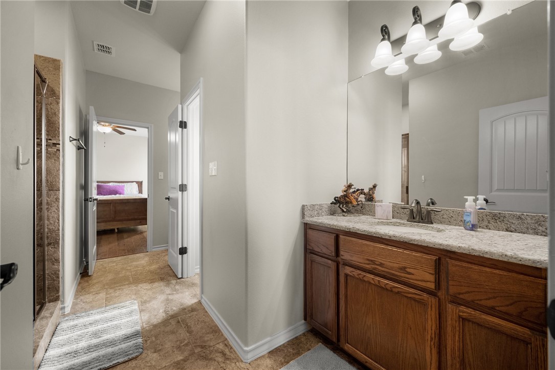 5310 Capernaum Court Corpus Christi, TX 78413 - Photo 25 of 40 a en suite bathroom with a granite countertop sink and a mirror