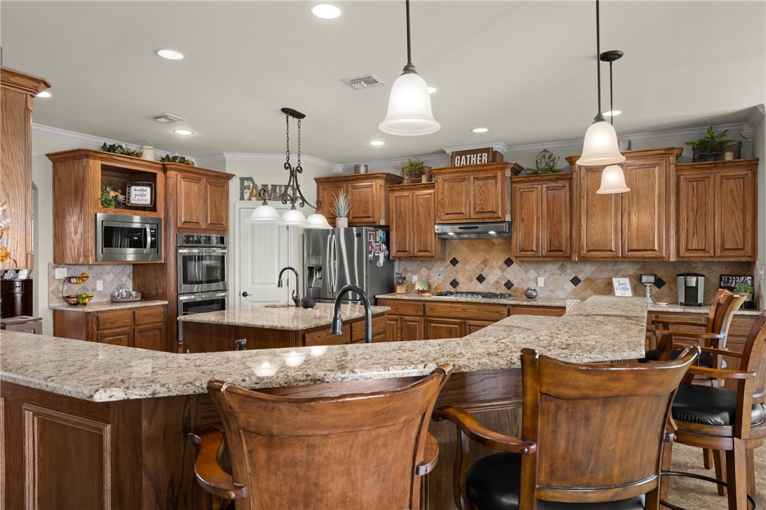 5310 Capernaum Court Corpus Christi, TX 78413 - Photo 8 of 40 a kitchen with granite countertop a sink a center island and cabinets