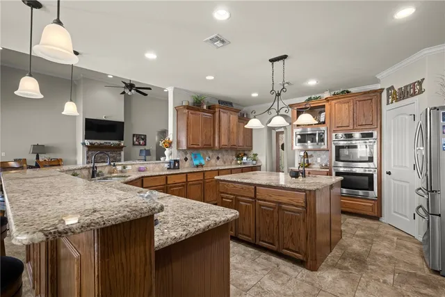 a kitchen with stainless steel appliances granite countertop a sink a stove and a refrigerator