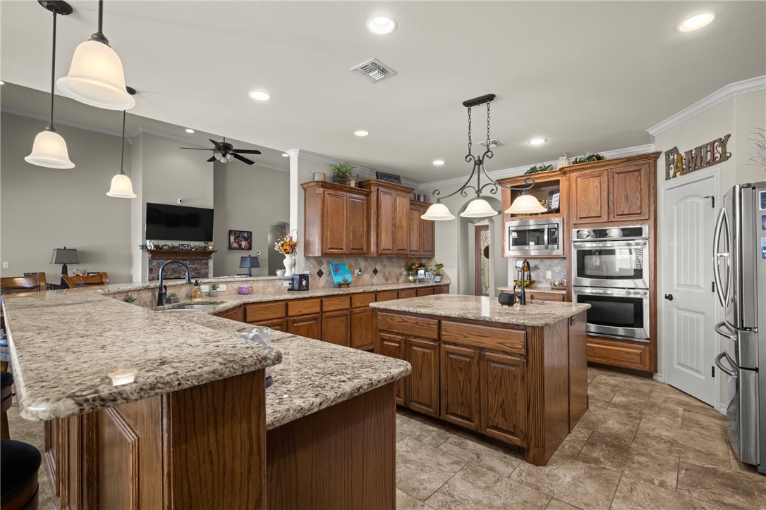 5310 Capernaum Court Corpus Christi, TX 78413 - Photo 10 of 40 a kitchen with stainless steel appliances granite countertop a sink a stove and a refrigerator