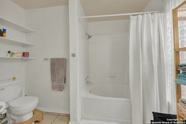 a bathroom with a shower curtain and a toilet