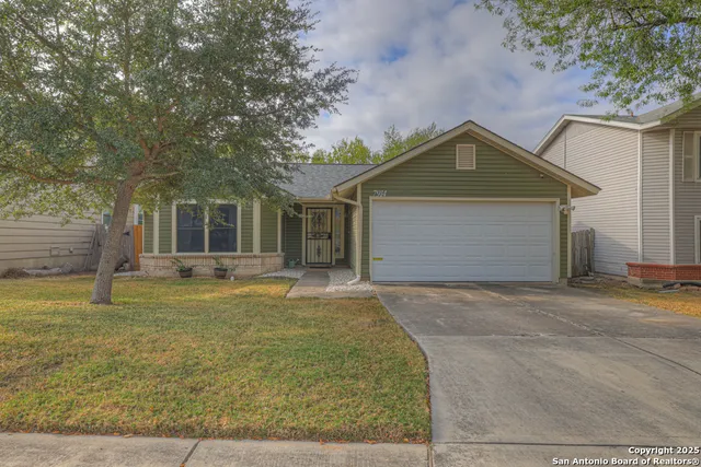 a front view of a house with a garden and tree