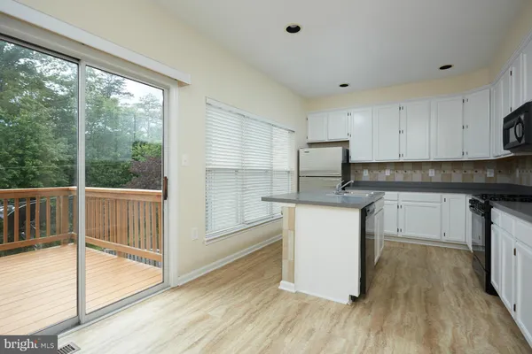 a view of empty room with wooden floor and windows
