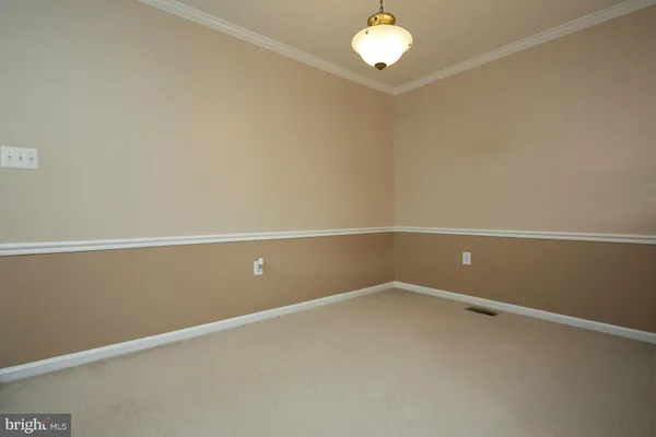 an empty room with chandelier fan