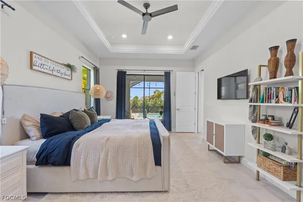 a bedroom with a bed a flat screen tv and a large window