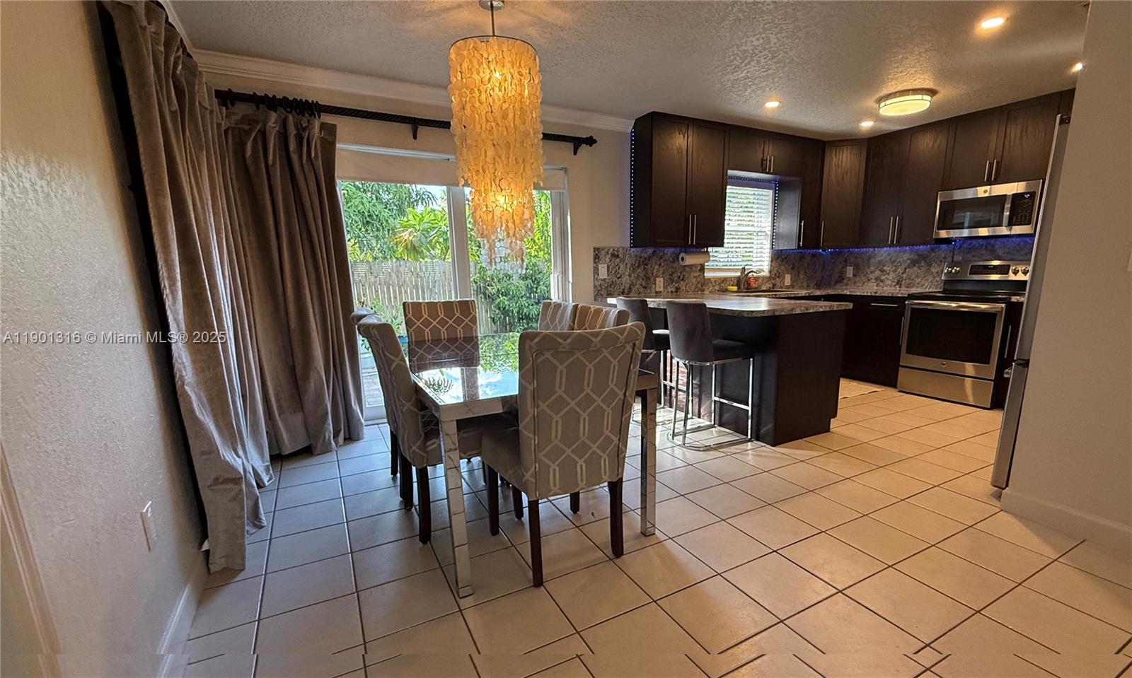 9546 Southwest Adams Avenue Okeechobee, FL 34974 - Photo 4 of 13 a kitchen with stainless steel appliances granite countertop sink refrigerator and microwave