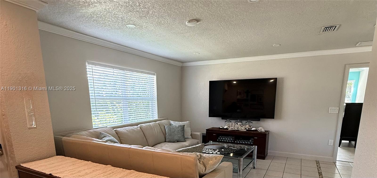 9546 Southwest Adams Avenue Okeechobee, FL 34974 - Photo 8 of 13 a living room with furniture and a flat screen tv