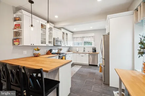a large kitchen with kitchen island a stove a sink a refrigerator and a refrigerator
