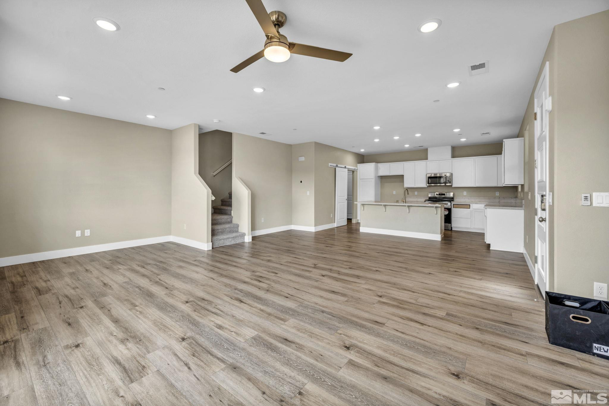 3660 Flare Lane, Unit 22 Carson City, NV 89705 - Photo 7 of 22 a view of a big room with wooden floor a ceiling fan and kitchen space