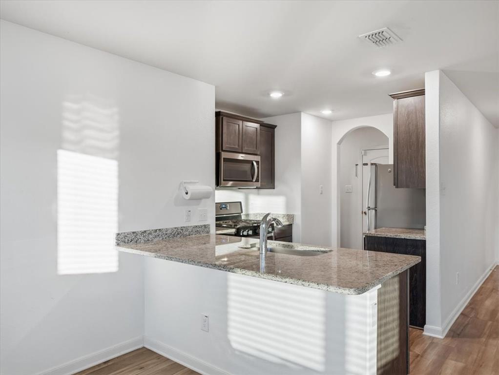 3083 Chillingham Drive Forney, TX 75126 - Photo 3 of 20 a kitchen with granite countertop a sink and a refrigerator