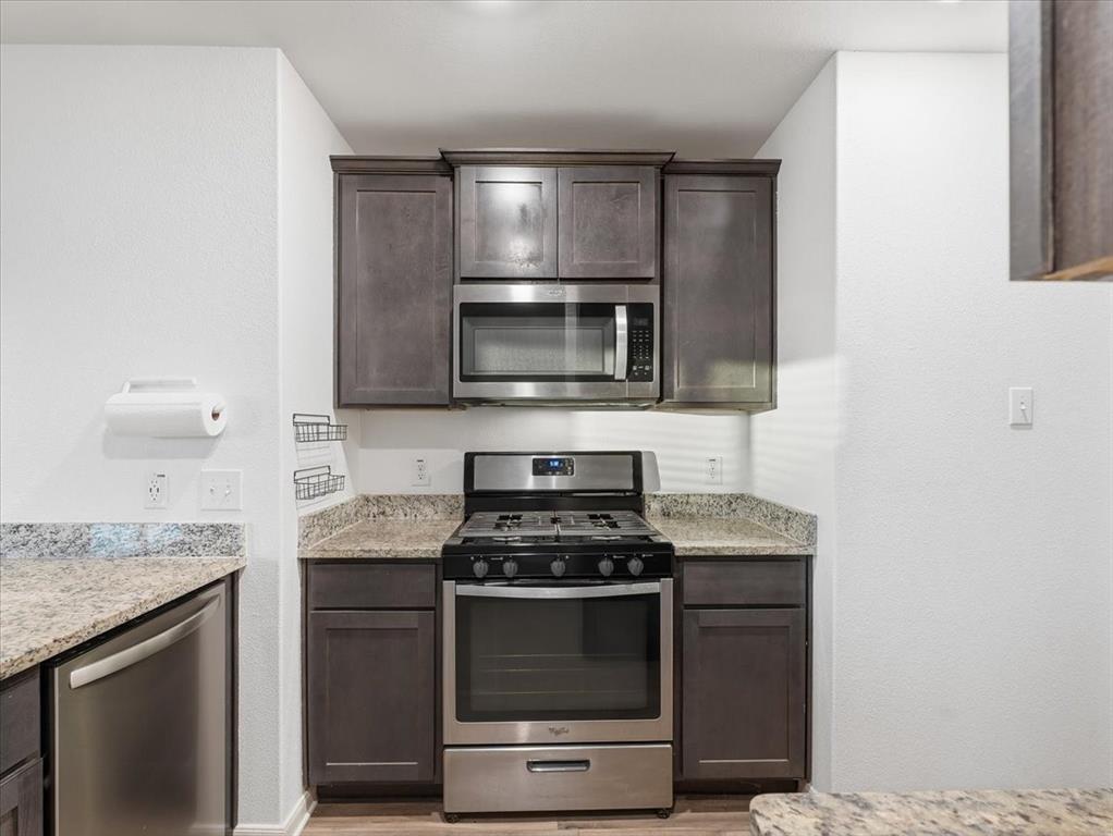 3083 Chillingham Drive Forney, TX 75126 - Photo 4 of 20 a kitchen with granite countertop a stove and a microwave