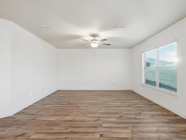 wooden floor in an empty room with a window
