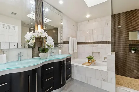 a bathroom with a bathtub sink and mirror