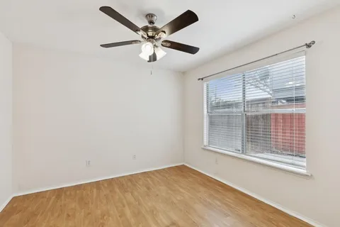 a view of an empty room and chandelier fan