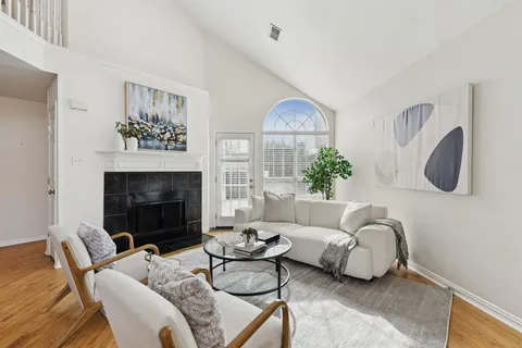a living room with furniture a chandelier and a fireplace
