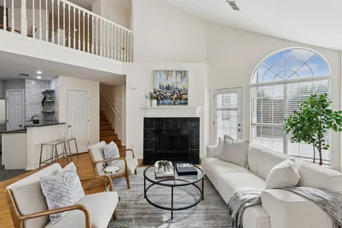 a living room with furniture kitchen view and a wooden floor