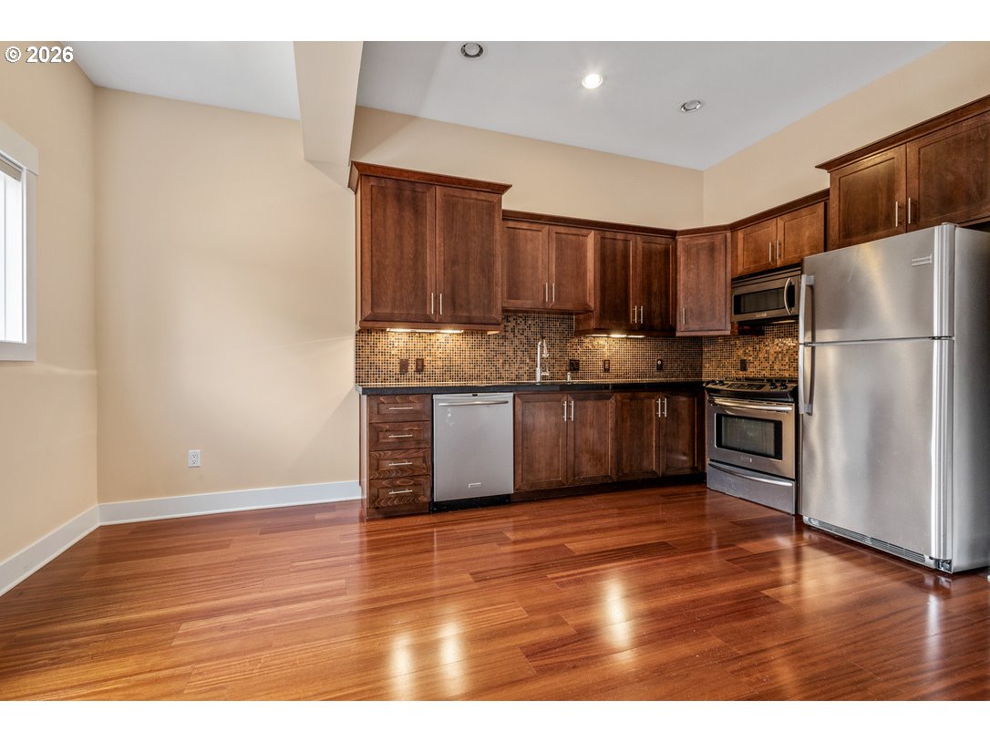 838 Southeast 38th Avenue, Unit 202 Portland, OR 97214 - Photo 11 of 34 a kitchen with granite countertop wooden floors and stainless steel appliances