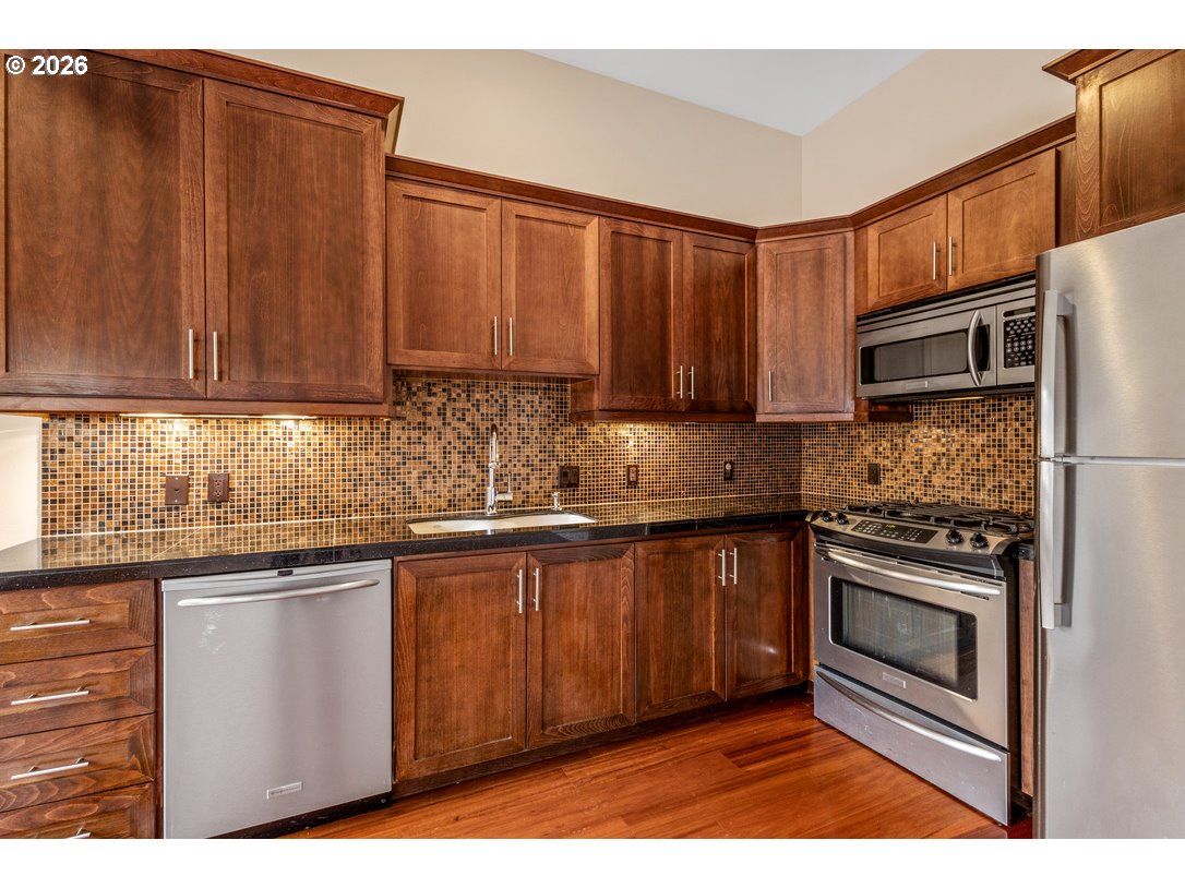 838 Southeast 38th Avenue, Unit 202 Portland, OR 97214 - Photo 12 of 34 a kitchen with stainless steel appliances granite countertop a stove a sink dishwasher and a refrigerator