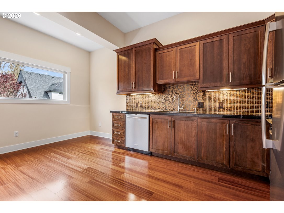 838 Southeast 38th Avenue, Unit 202 Portland, OR 97214 - Photo 14 of 34 a kitchen with granite countertop wooden cabinets a sink and dishwasher