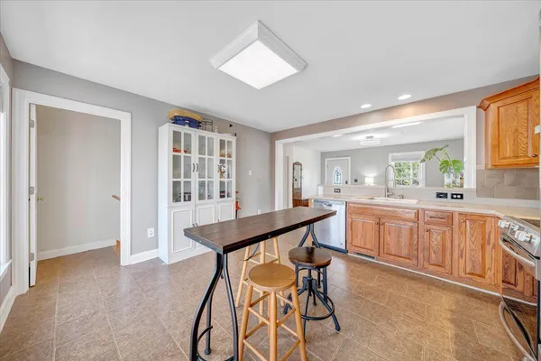 a kitchen with stainless steel appliances kitchen island granite countertop wooden cabinets and dining table