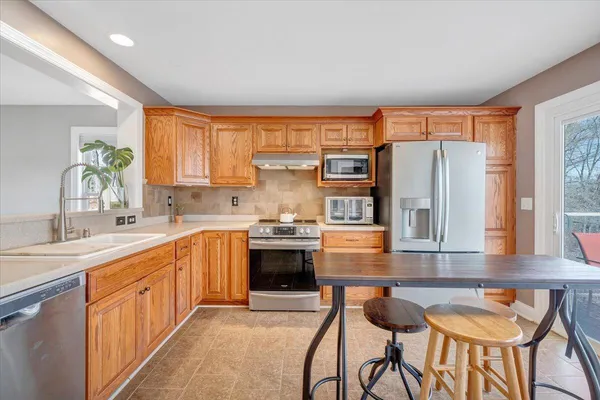 a kitchen with granite countertop a sink stove and refrigerator
