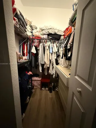 a view of walk in closet with clothes and shoes