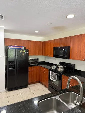 a kitchen with stainless steel appliances granite countertop a refrigerator and a stove
